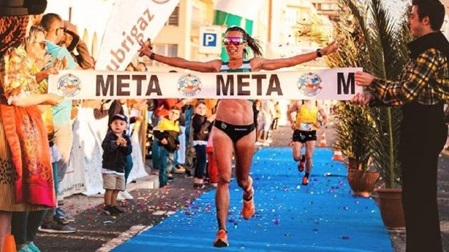 female runner crosses finish line