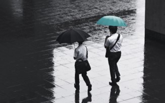 two persons walking in the rain